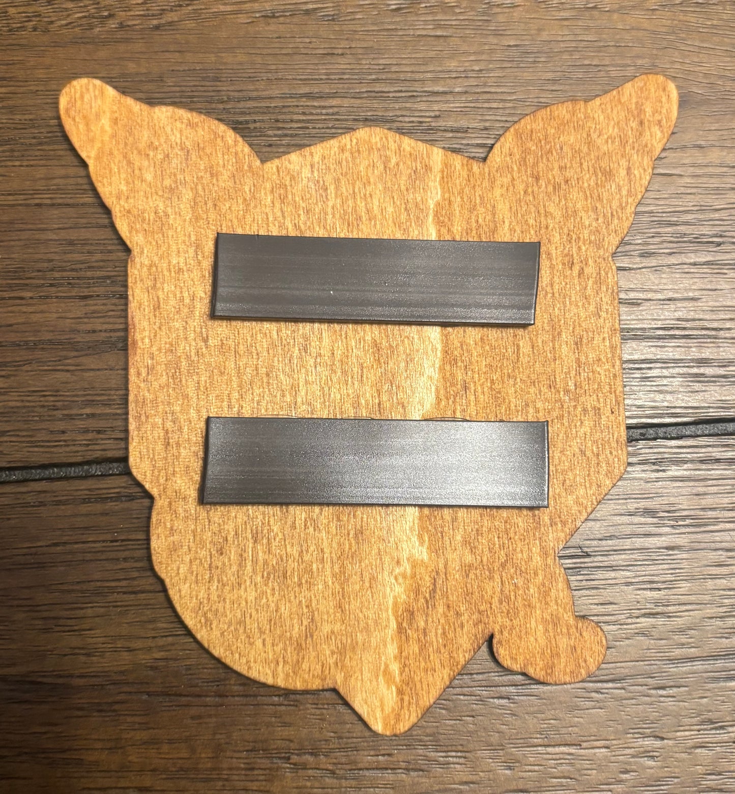 Stained basswood fridge magnet of a the Team Mystic logo from the Pokemon video games