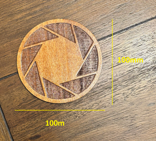 Stained basswood fridge magnet of the Aperture logo from the Portal video game