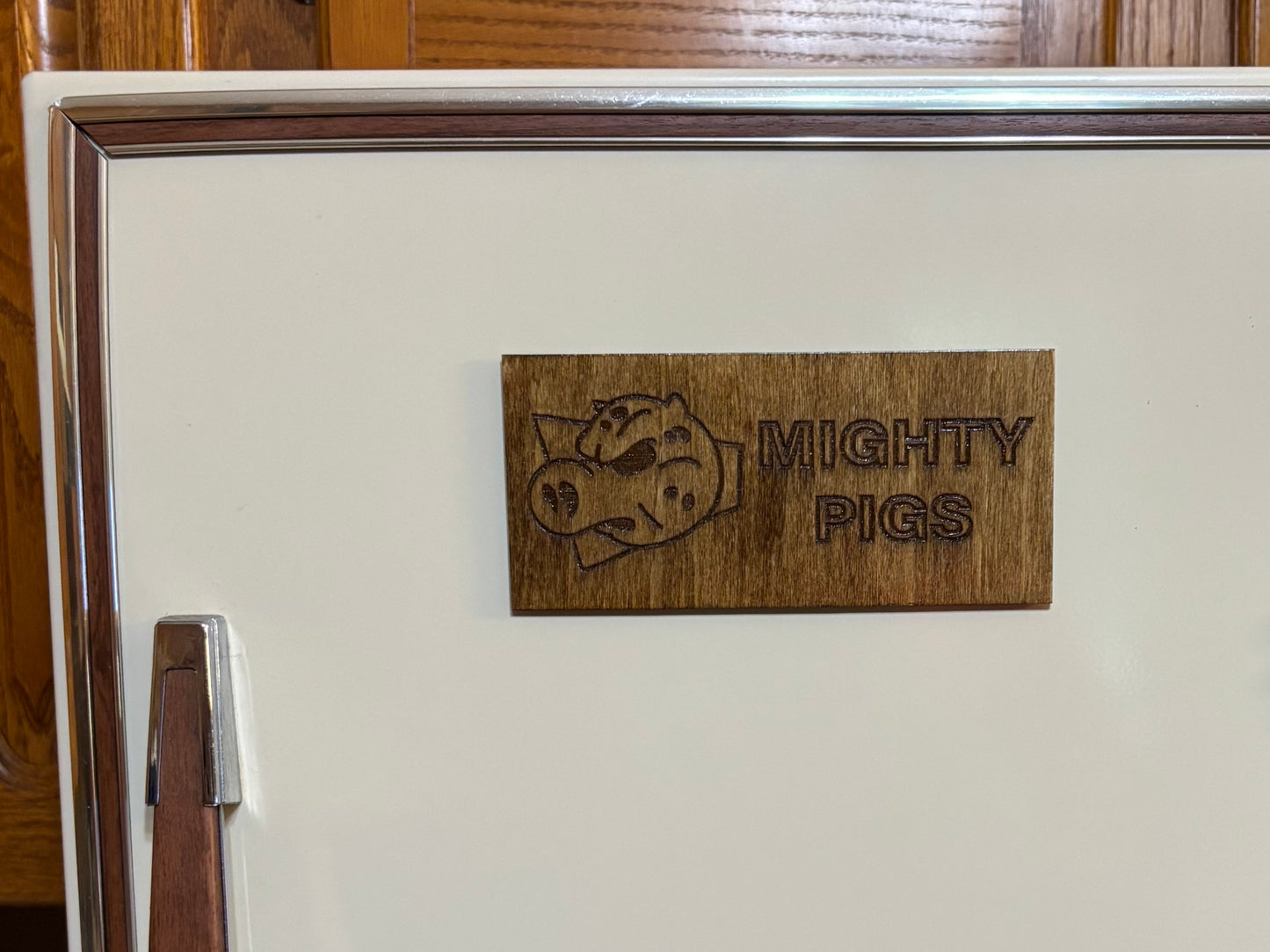 Stained basswood fridge magnet of the Mighty Pigs logo from the Simpsons