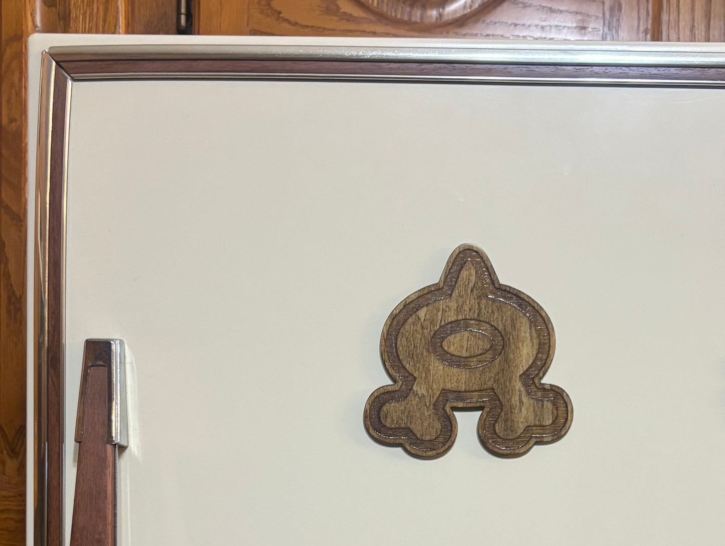 Stained basswood fridge magnet of a the Team Aqua logo from the Pokemon video games