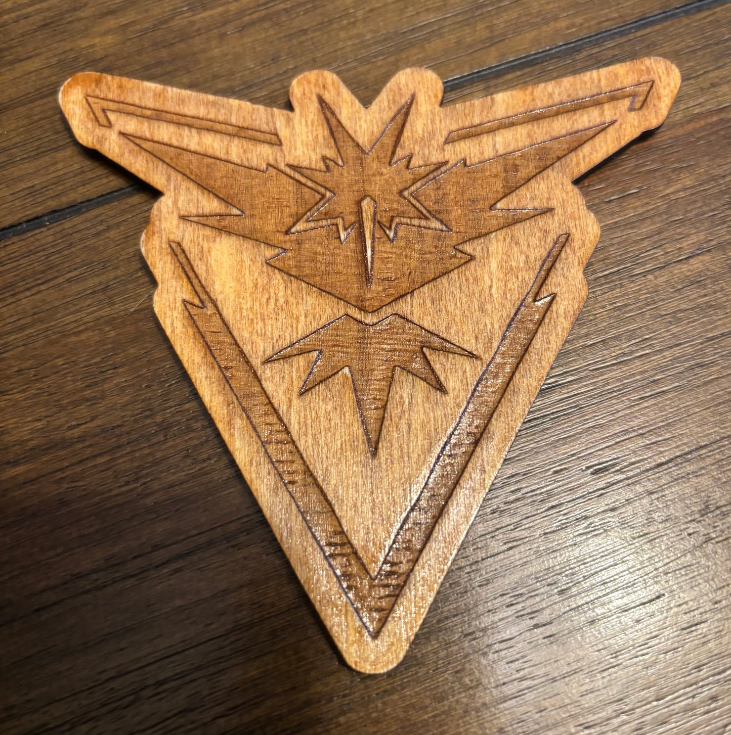 Stained basswood fridge magnet of a the Team Instinct logo from the Pokemon video games