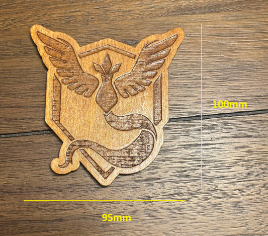 Stained basswood fridge magnet of a the Team Mystic logo from the Pokemon video games