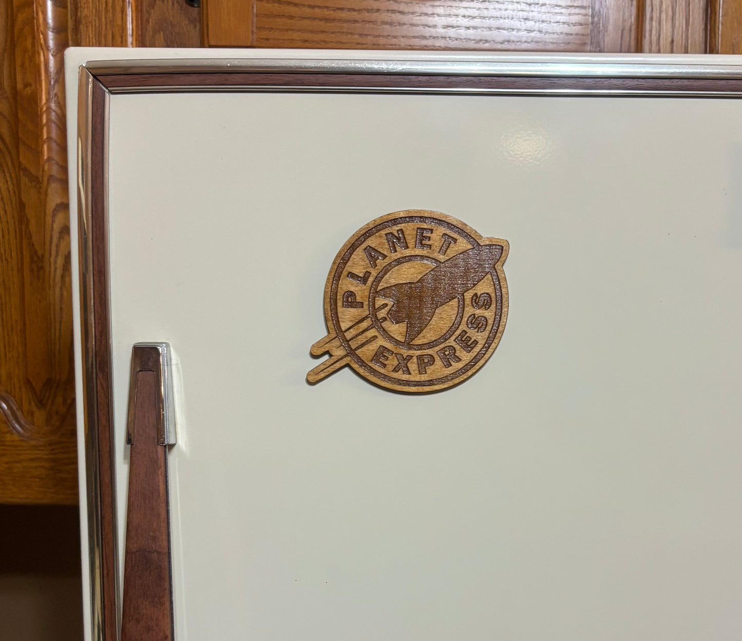 Stained basswood fridge magnet of the Planet Express logo from Futurama