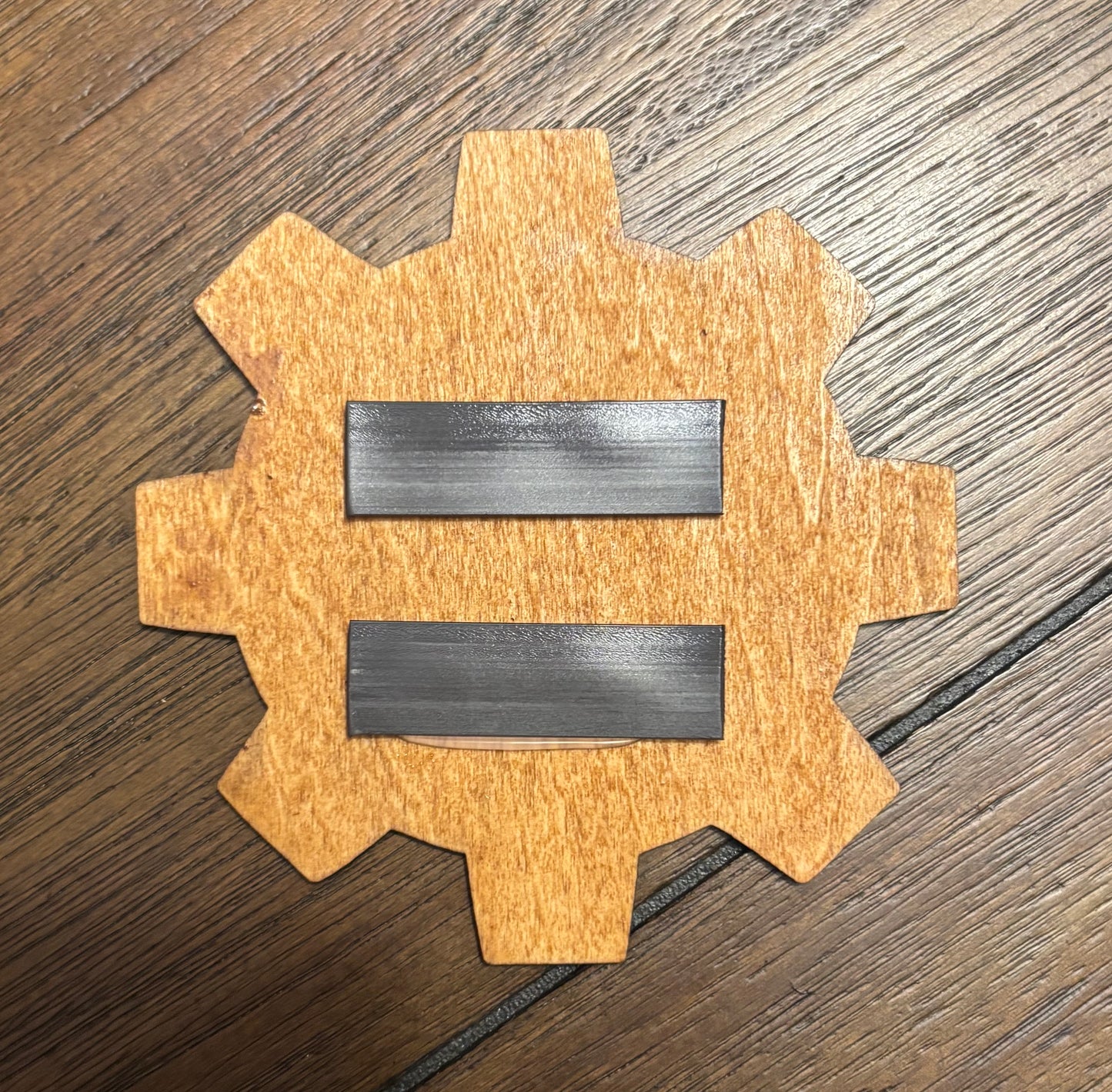Stained basswood fridge magnet of the Vault-Tec logo from the Fallout video games