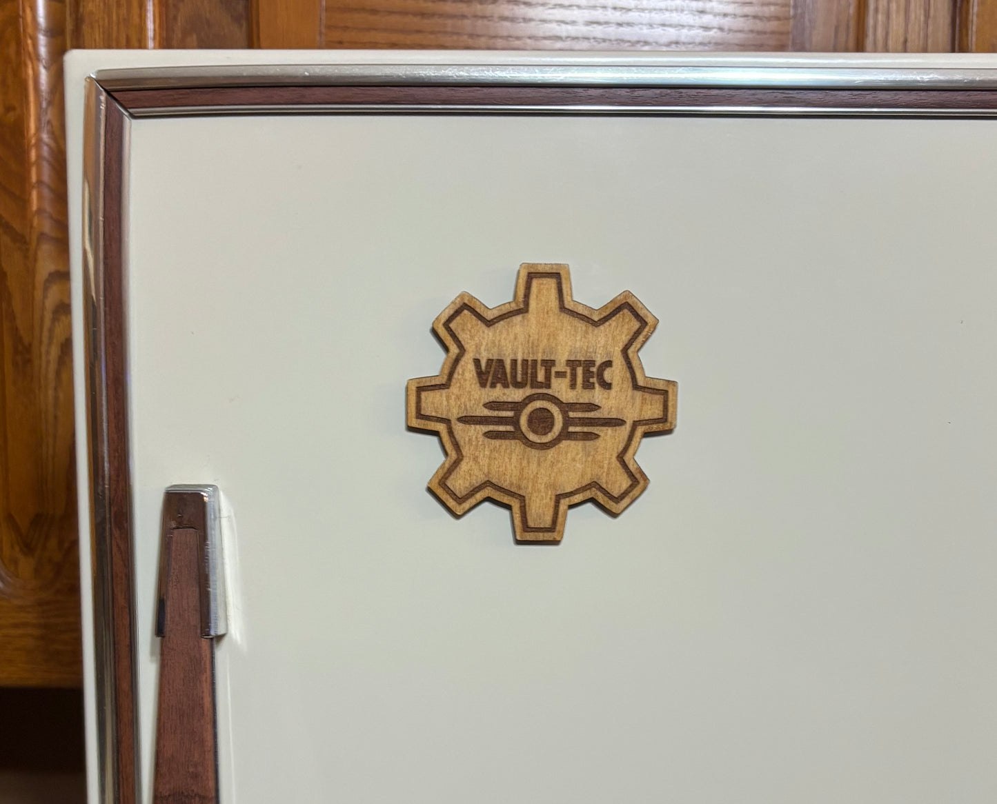 Stained basswood fridge magnet of the Vault-Tec logo from the Fallout video games
