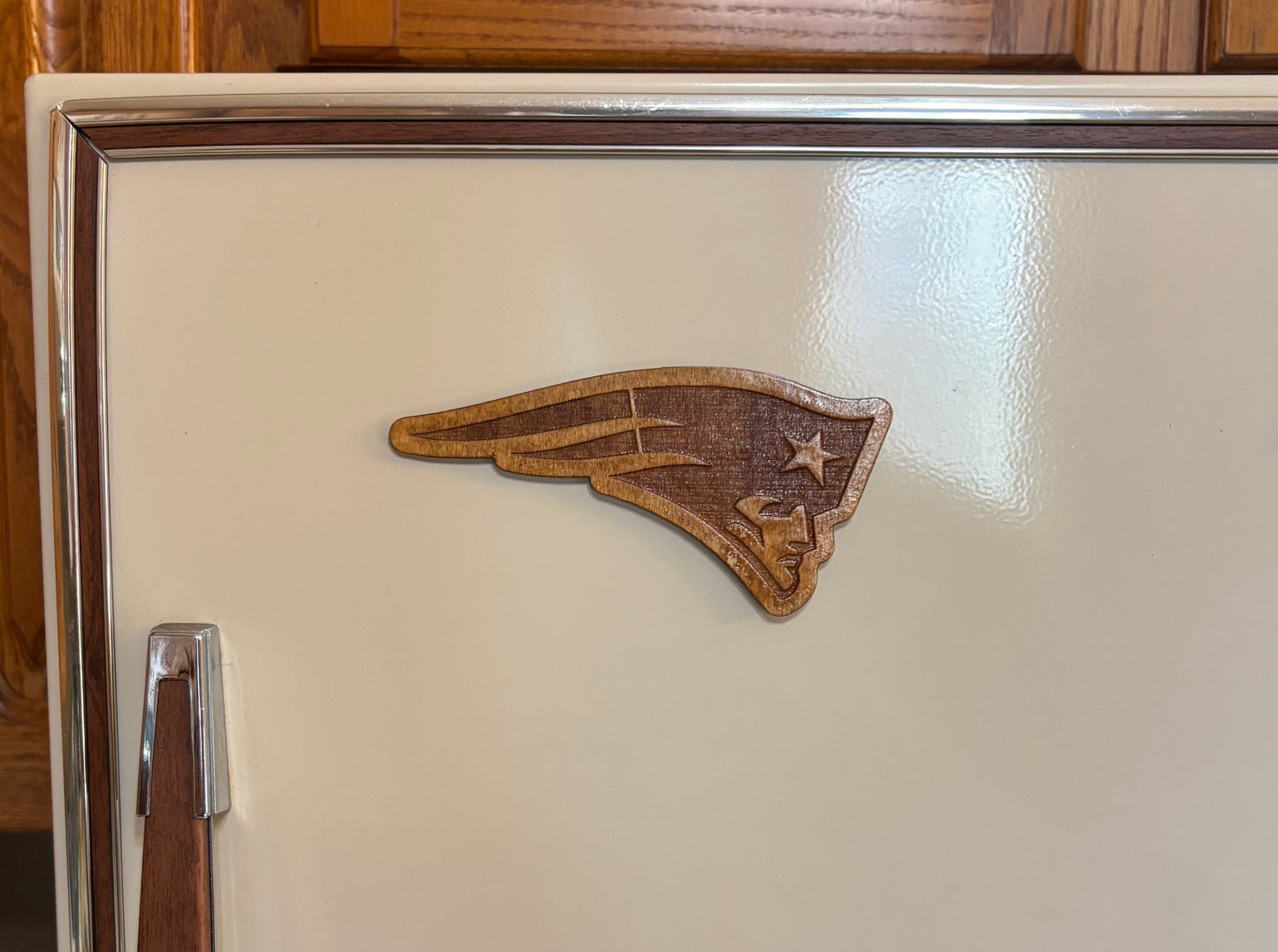 Stained basswood fridge magnet of the New England Patriots football team logo