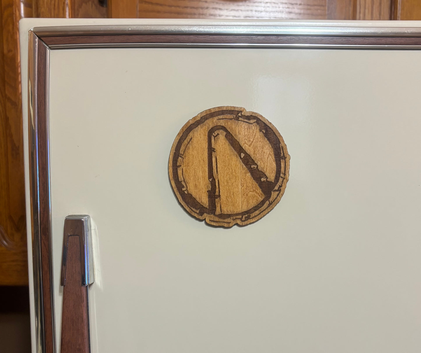 Stained basswood fridge magnet of the weathered Vault logo from the Borderlands video games