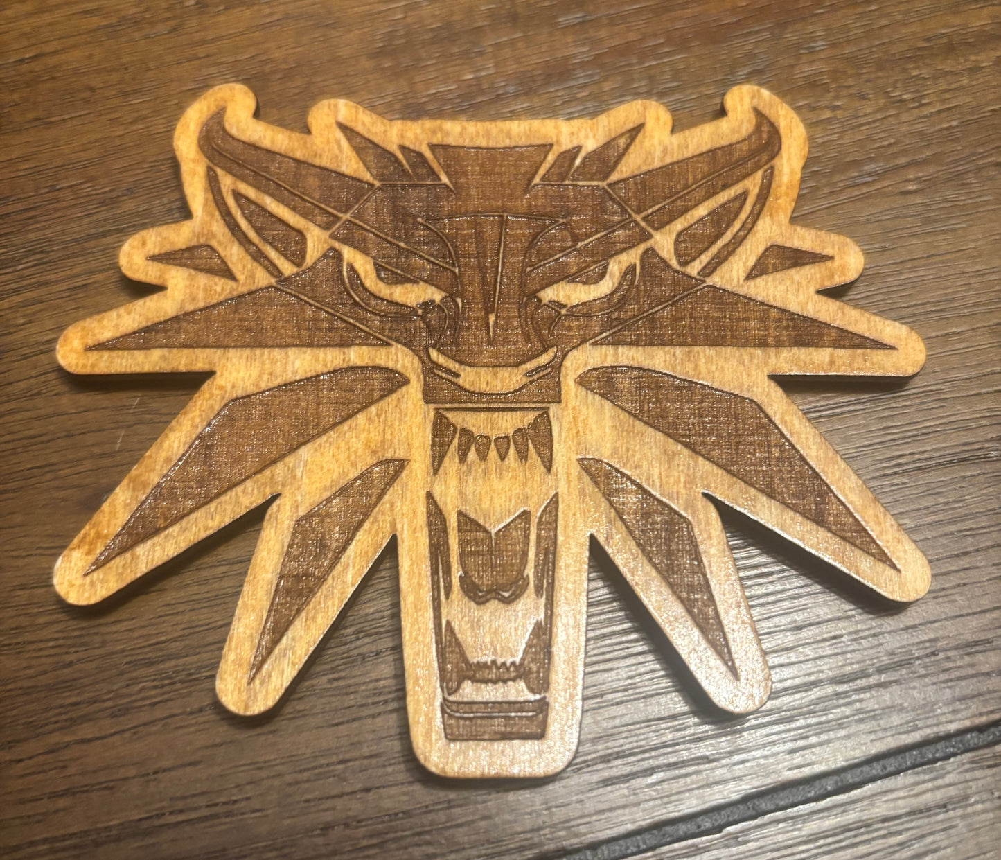 Stained basswood fridge magnet of the Witcher logo