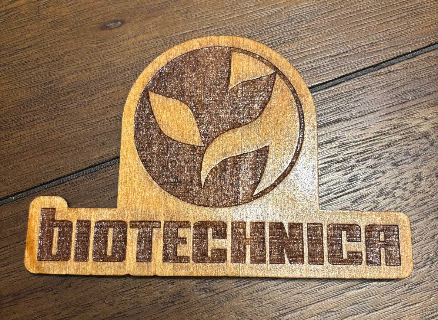 Stained basswood fridge magnet of the Biotechnica logo from the Cyberpunk 2077 video game