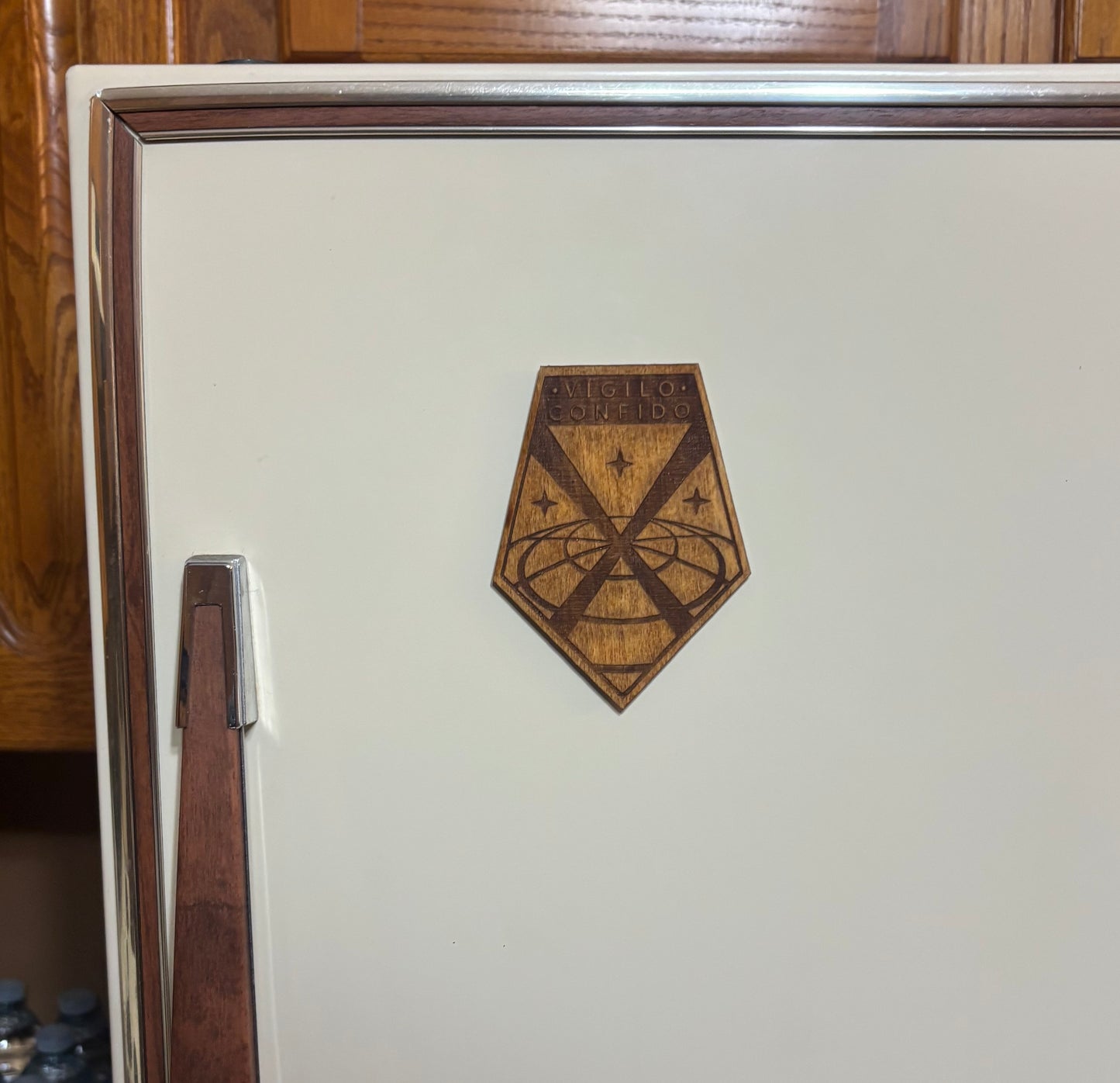 Stained basswood fridge magnet of the X-COM logo