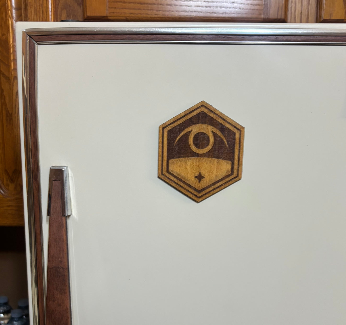 Stained basswood fridge magnet of the Exalt logo from the X-COM video games